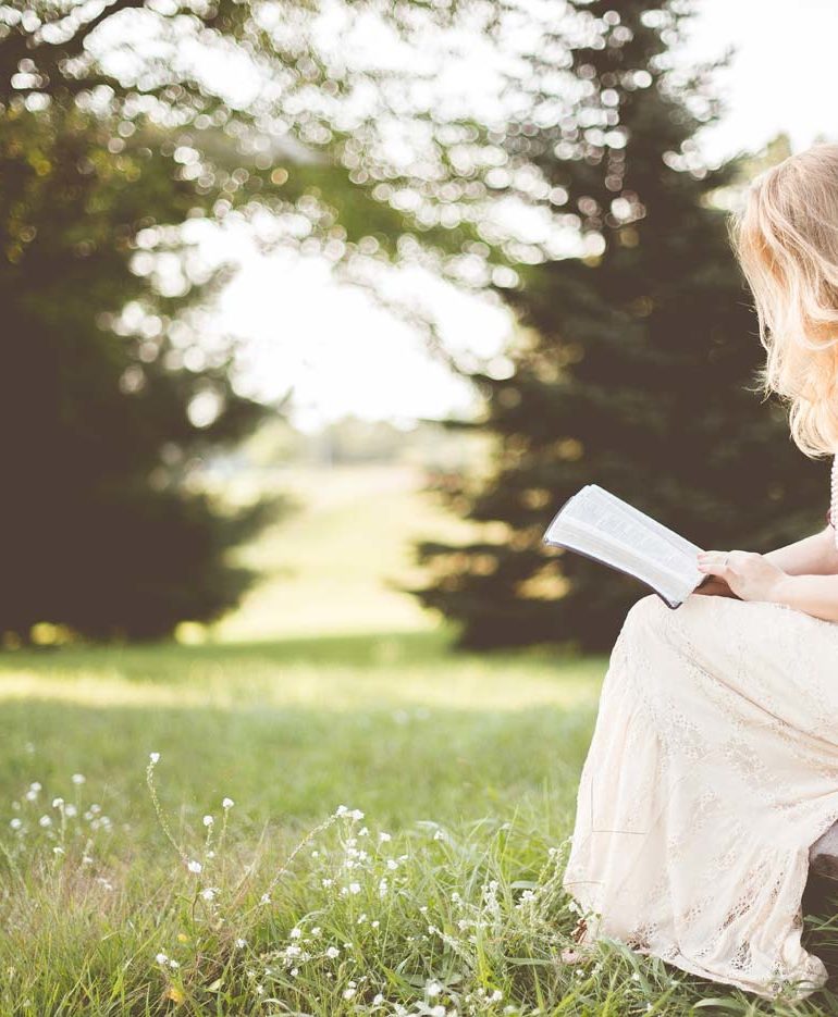 kobieta czyta książkę na łonie natury