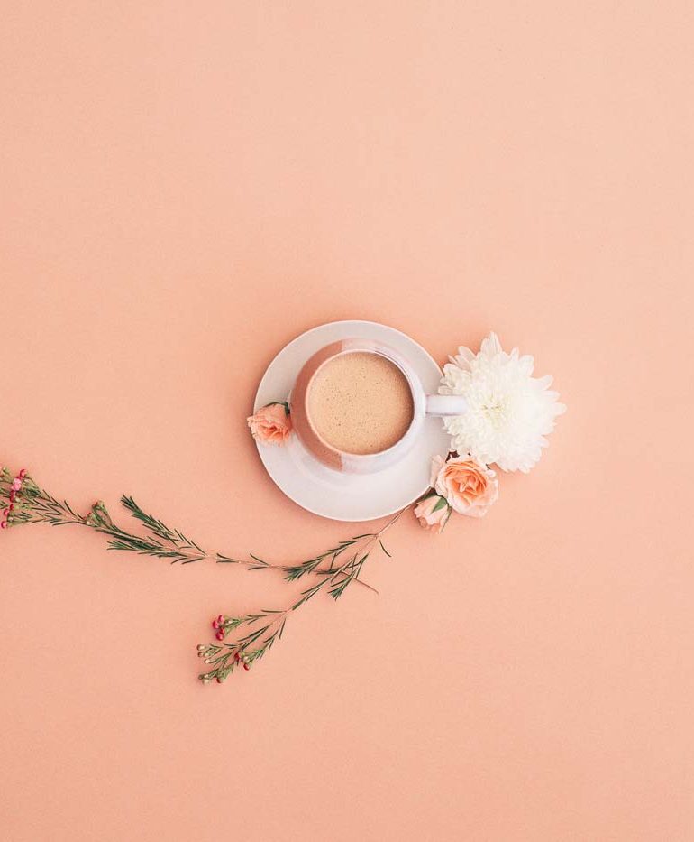 filiżanka kawy z kwiatami obok