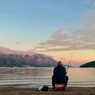 Wędkarz łowiący ryby o wschodzie słońca – relaksujące hobby na świeżym powietrzu.