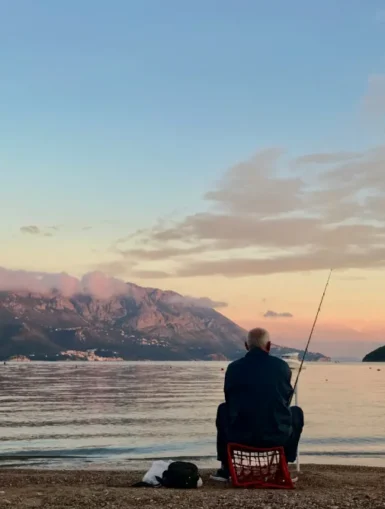 Wędkarz łowiący ryby o wschodzie słońca – relaksujące hobby na świeżym powietrzu.